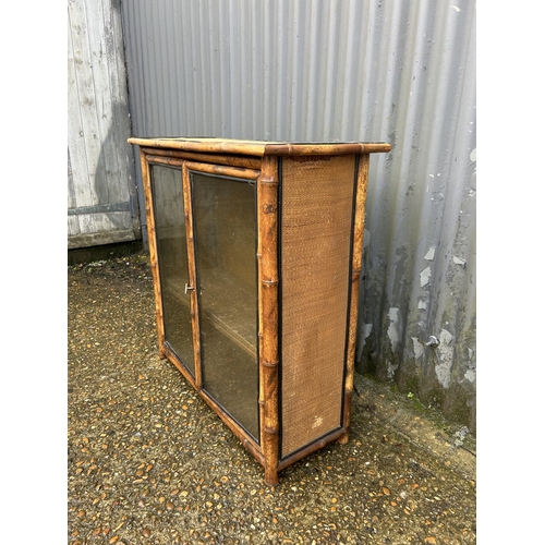 7 - An antique bamboo two door glazed bookcase 78x30x77