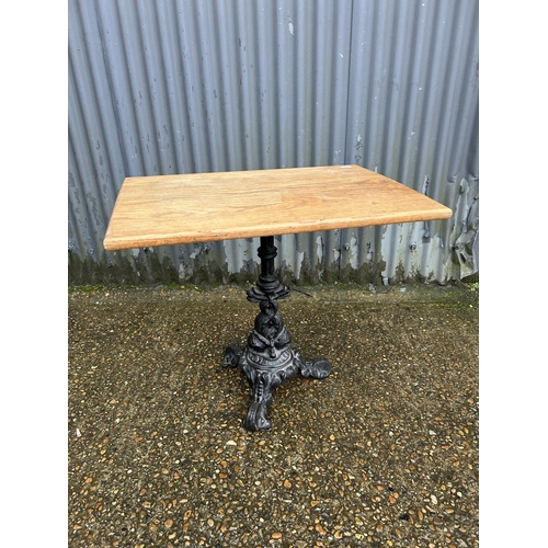 84 - An ornate cast iron pub table with oak top  80x56x70