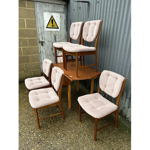 87 - A mid century teak drop leaf dining table together with a set of 6 danish style teak dining chairs w... 