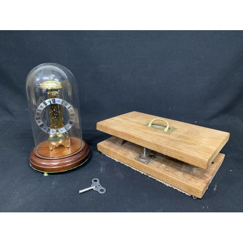 621 - Domed clock, with key, height 31cms and book press