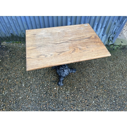 84 - An ornate cast iron pub table with oak top  80x56x70