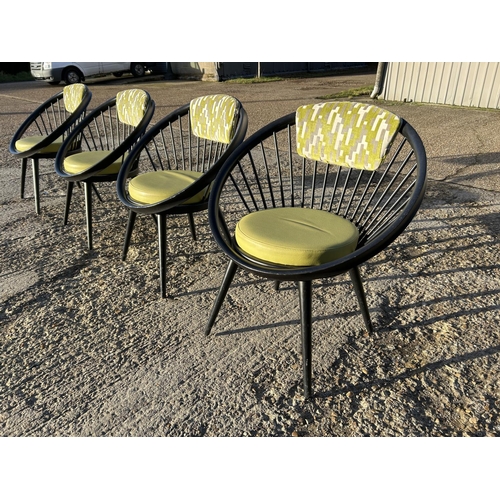 281 - A set of four Black stick back Vitra style designer chairs with Green Upholstery