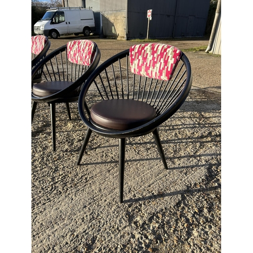 282 - A set of four Black stick back Vitra style designer chairs with pink Upholstery