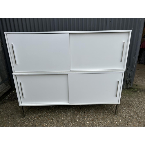 134 - A modern white gloss two section cupboard with sliding doors 150x40x127