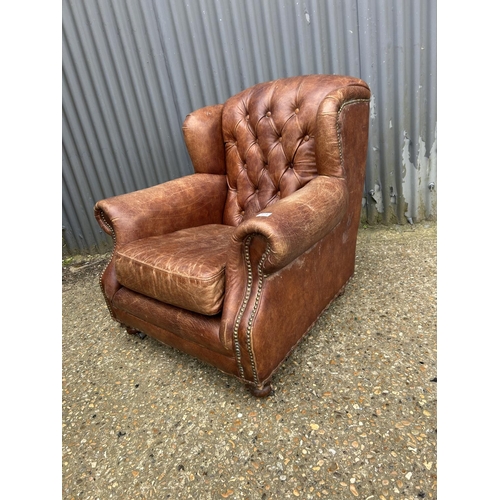 171 - A brown leather button back club armchair