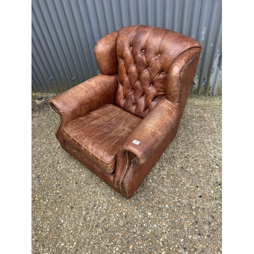171 - A brown leather button back club armchair