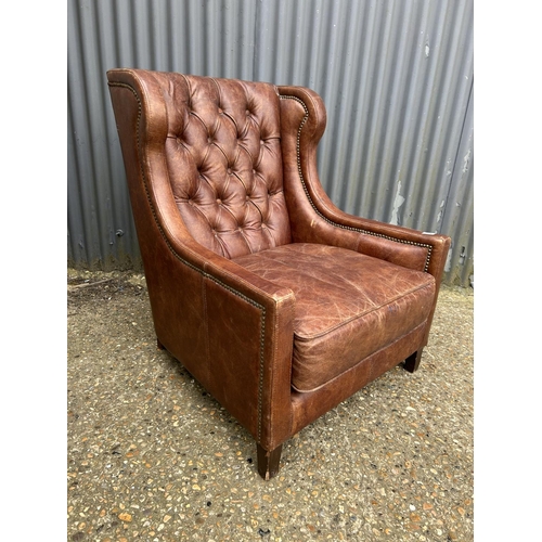 172 - A brown leather button back club armcchair