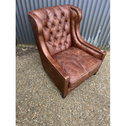 172 - A brown leather button back club armcchair