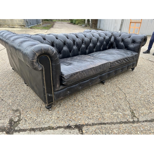 174 - An unusual thick black leather back to back chesterfield sofa with brass studwork 170x240