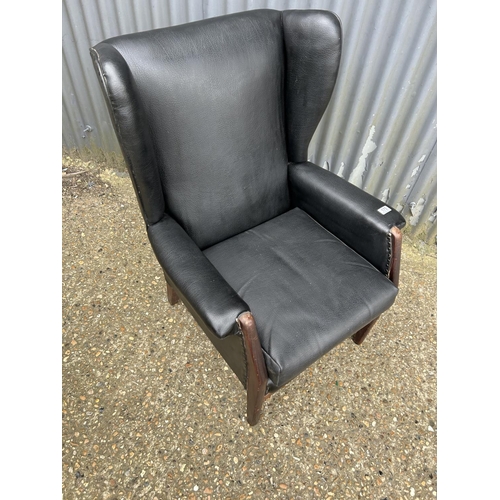 175 - A retro teak and black vinyl fireside chair