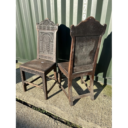 250 - A pair of antique oak chairs with carved panel backs