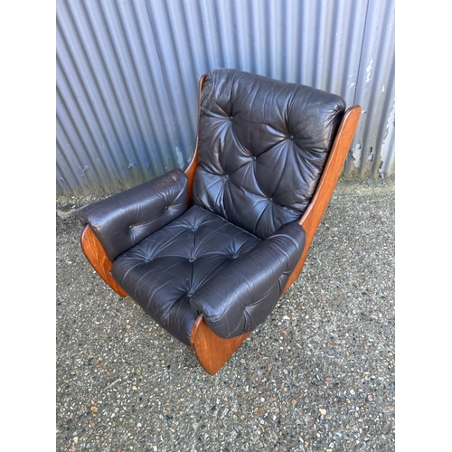 36 - A mid century teak framed g plan or similar armchair with brown leather upholstery