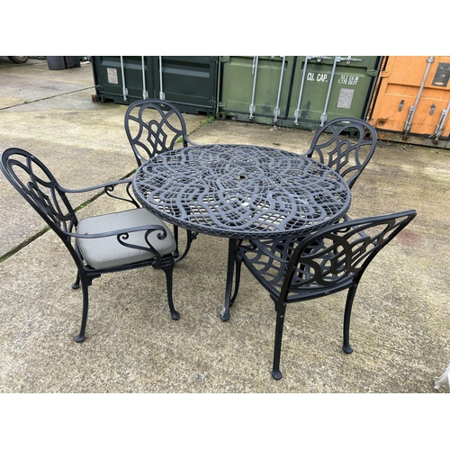 361 - A large modern aluminium garden table with four carver chairs 124cm diameter