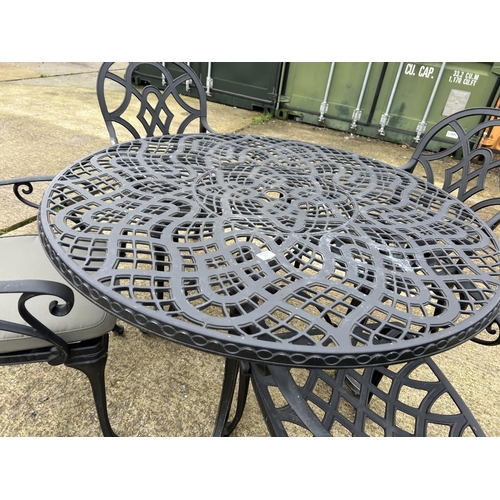 361 - A large modern aluminium garden table with four carver chairs 124cm diameter