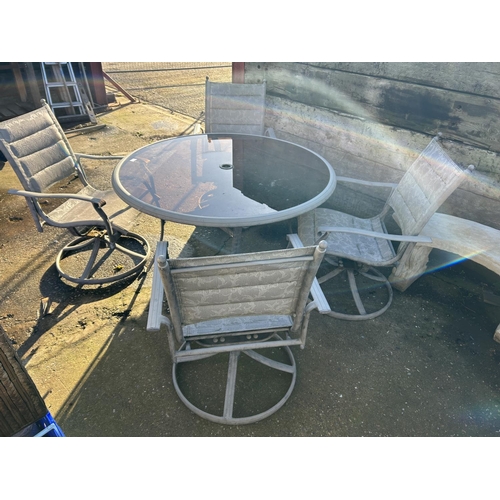 369 - A circular glass top garden table with four swivel chairs