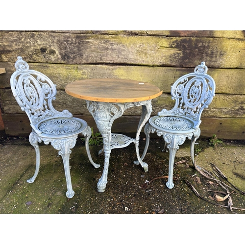 372 - A blue painted ornate iron based garden table with 2 chairs