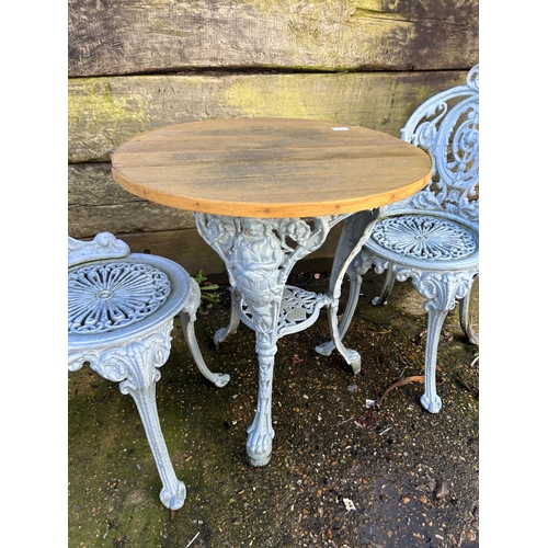 372 - A blue painted ornate iron based garden table with 2 chairs