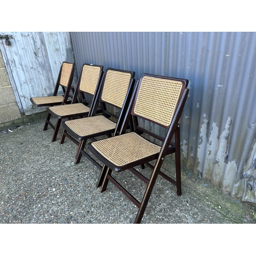 49 - A set of four folding ebonised Gilles cane chairs