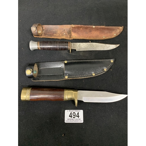 494 - 2 small hunting knives in leathers sheaths, 1 marked 