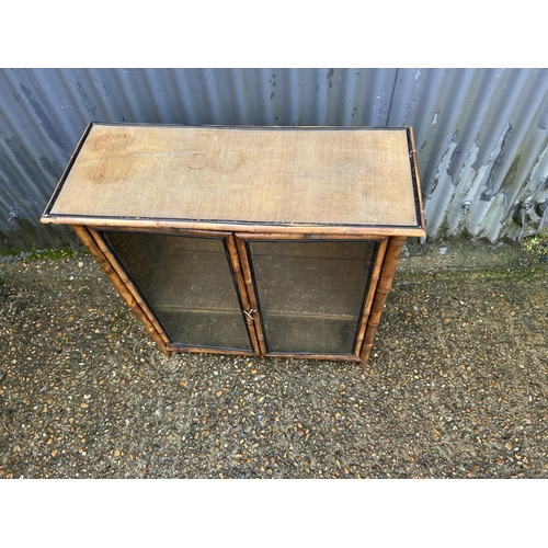 221 - An antique bamboo two door glazed bookcase 78x30x77