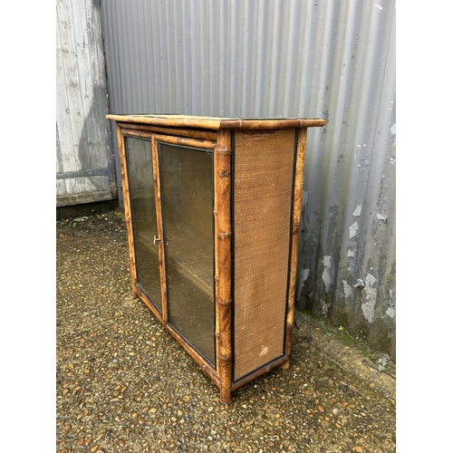 221 - An antique bamboo two door glazed bookcase 78x30x77