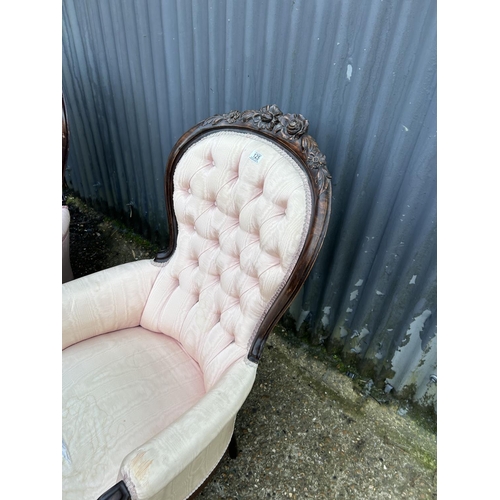 223 - An ornate pair of mahogany framed button back chairs with pink upholstery