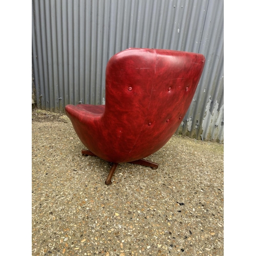 1 - A mid century red vinyl swivel lounge chair with teak four pointed base