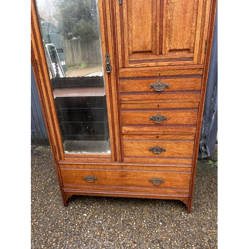 141 - An Edwardian oak combination wardrobe / chest with single mirror door and four drawers 107x46x200