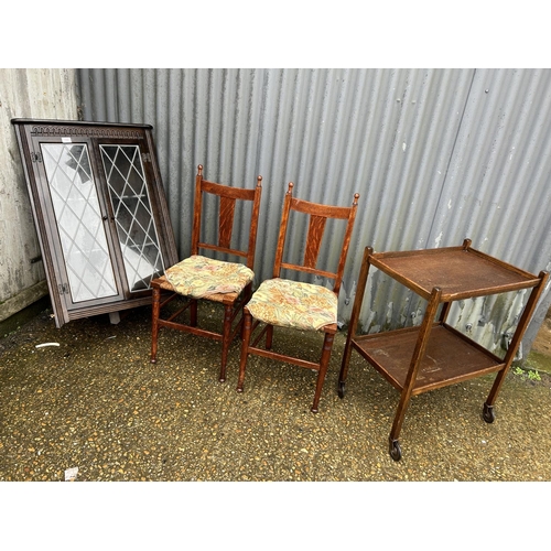 152 - A oak corner cabinet, two oak chairs and oak tea trolley