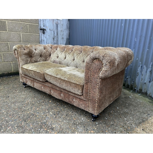164 - A leopard pattern fabric  two seater chesterfield sofa 180cm wide