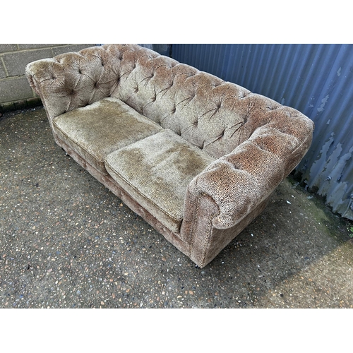 164 - A leopard pattern fabric  two seater chesterfield sofa 180cm wide