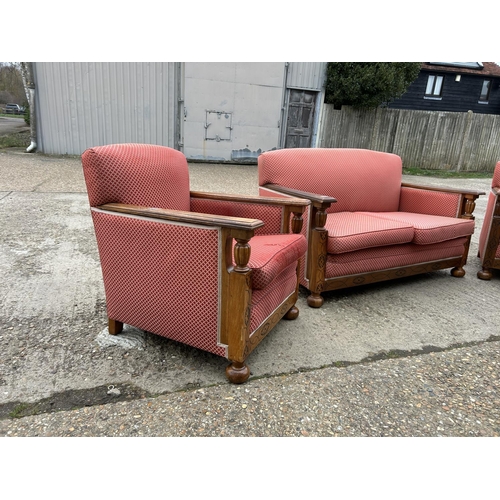 23 - An early 20th century oak framed three piece lounge suite consisting of two seater sofa with two cha... 