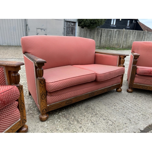 23 - An early 20th century oak framed three piece lounge suite consisting of two seater sofa with two cha... 