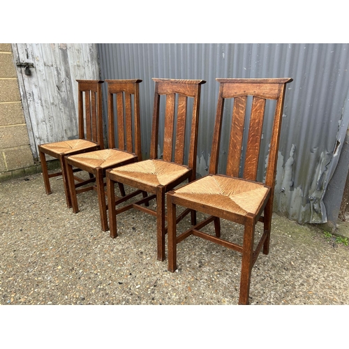 24 - A set of four arts and crafts dining chairs with rush seats