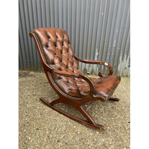25 - A brown leather chesterfield rocking chair