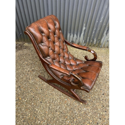 25 - A brown leather chesterfield rocking chair