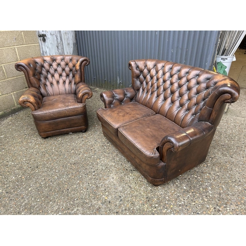 26 - A brown leather chesterfield two seater sofa together with a matching armchair (chair af to arm)