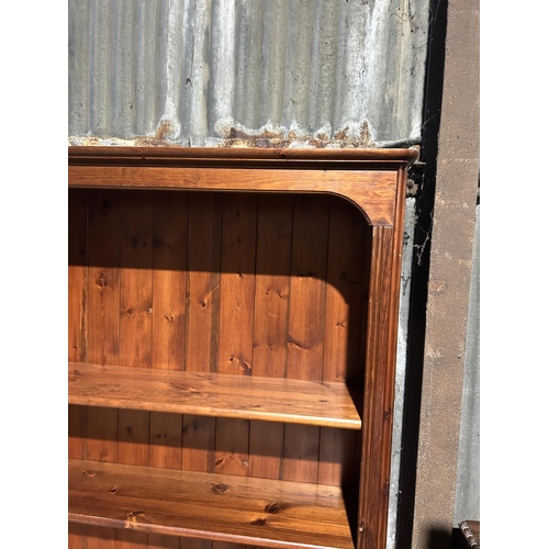 1 - A tall ducal pine open fronted bookcase