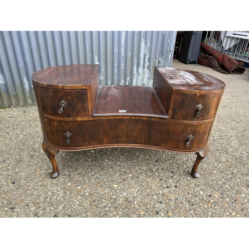 105 - A walnut kidney shaped chest of three drawer