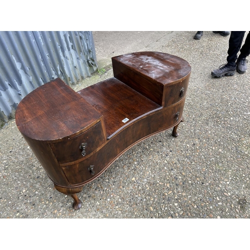 105 - A walnut kidney shaped chest of three drawer