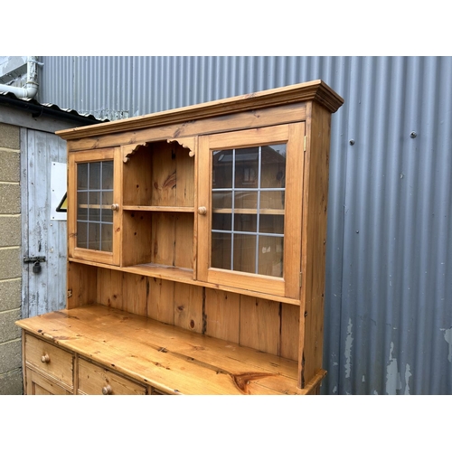 157 - A solid pine dresser with leaded glass plate rack back over three drawer base 156 cm wide