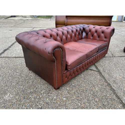 165 - A red leather chesterfield three seater sofa