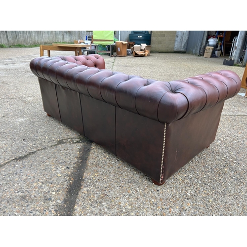 165 - A red leather chesterfield three seater sofa