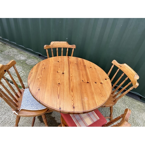 196 - A circular pine kitchen table and four chairs