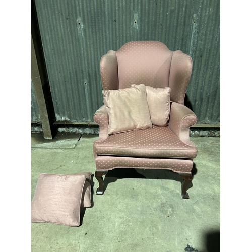 21 - A pink upholstered wing back armchair with 4 cushions