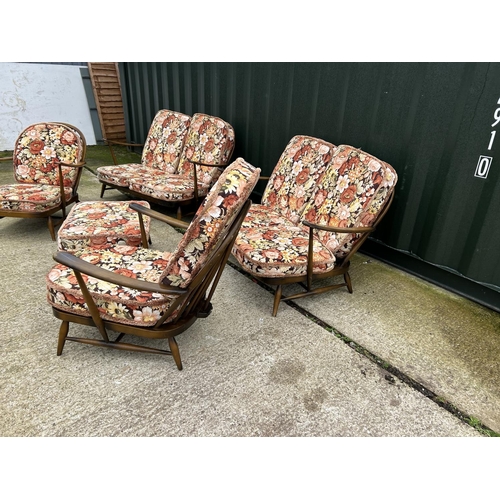 221 - An Ercol dark elm five piece lounge suite consisting two sofas, one chair and a footstool