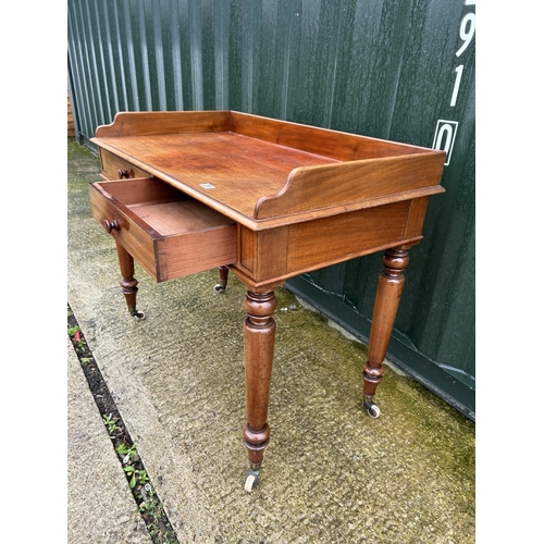 236 - A Victorian mahogany two drawer writing table with gallery top 107x68x90