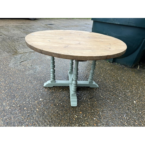 265 - A country pine circular kitchen table with green painted base 120cm diameter