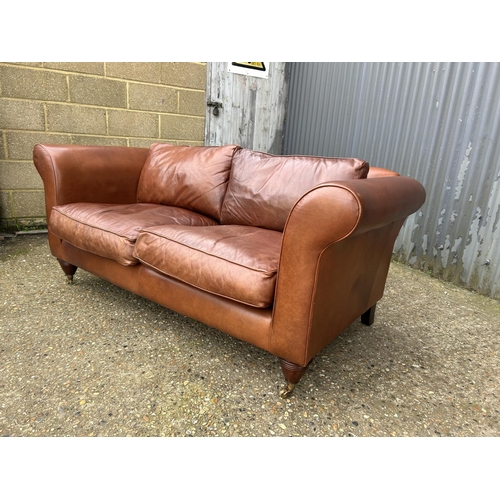 28 - A good quality tan brown leather two seater sofa by LAURA ASHLEY 185cm wide