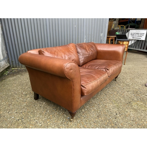 28 - A good quality tan brown leather two seater sofa by LAURA ASHLEY 185cm wide